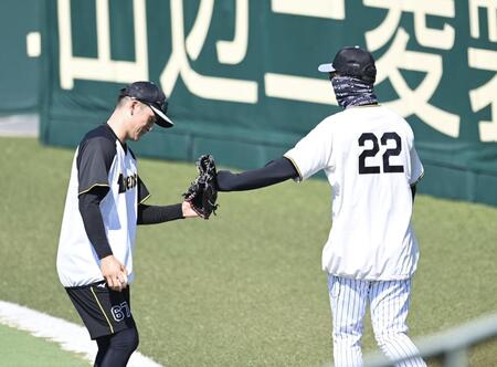 　守備練習中の高寺とタッチを交わす藤川監督