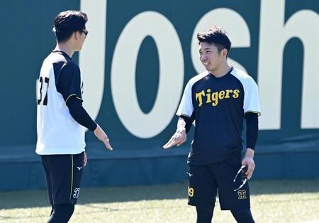 　及川（左）と談笑する石井（撮影・飯室逸平）