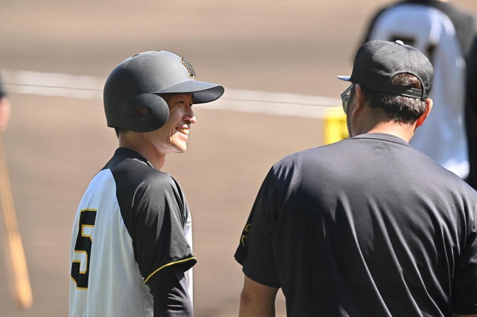 　小谷野コーチ（右）と笑顔で話をする近本（撮影・西田忠信）