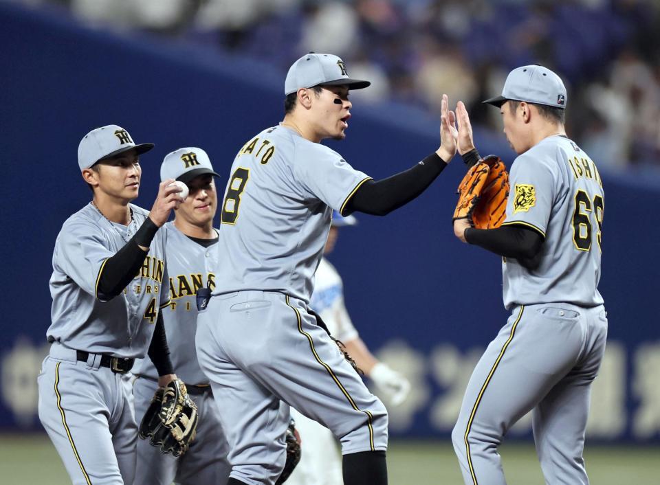 ９回、最後を締めた石井（右）とタッチを交わす佐藤輝（撮影・田中太一）