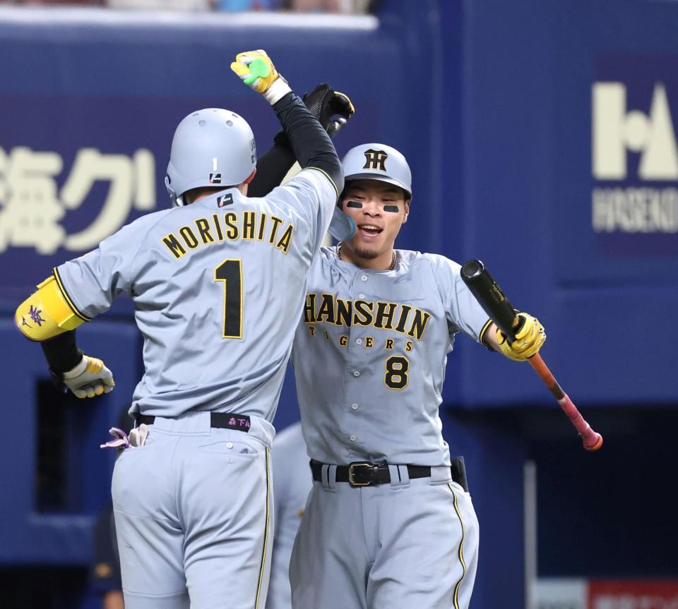 　６回、ソロを放った森下（１）を迎える佐藤輝（撮影・北村雅宏）