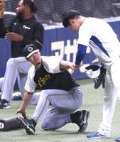 　練習中に清水とグータッチを交わす佐藤輝（左）＝撮影・北村雅宏