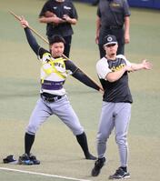 　ウオーミングアップをする森下（左）と佐藤輝（撮影・立川洋一郎）