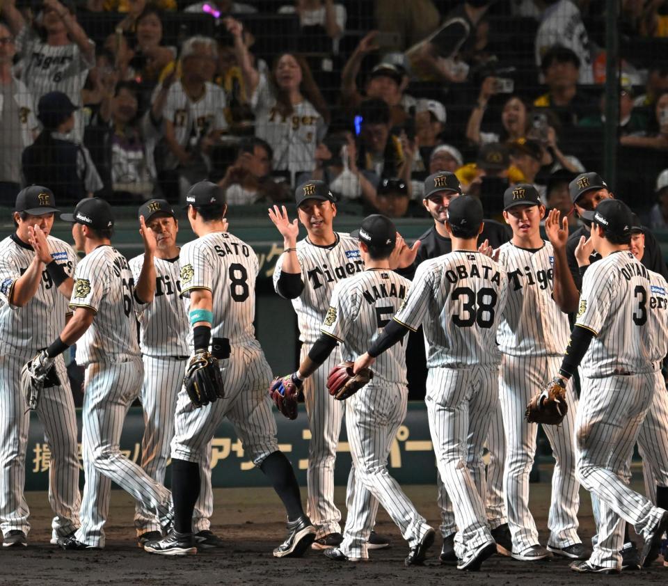 　ハイタッチでナインを迎える藤川監督（中央）＝撮影・飯室逸平