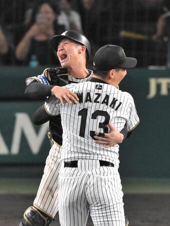 　セ・リーグ優勝を決め、抱き合って喜ぶ坂本（左）と岩崎