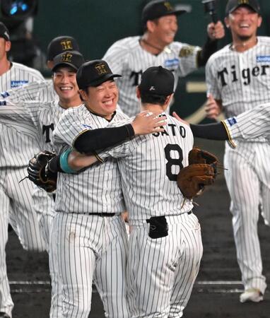 　優勝を決め、佐藤輝（８）と抱き合って喜ぶ大山（撮影・飯室逸平）