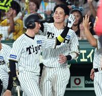 　６回、犠飛で追加点を挙げた近本（左）は木浪に迎えられる（撮影・田中太一）