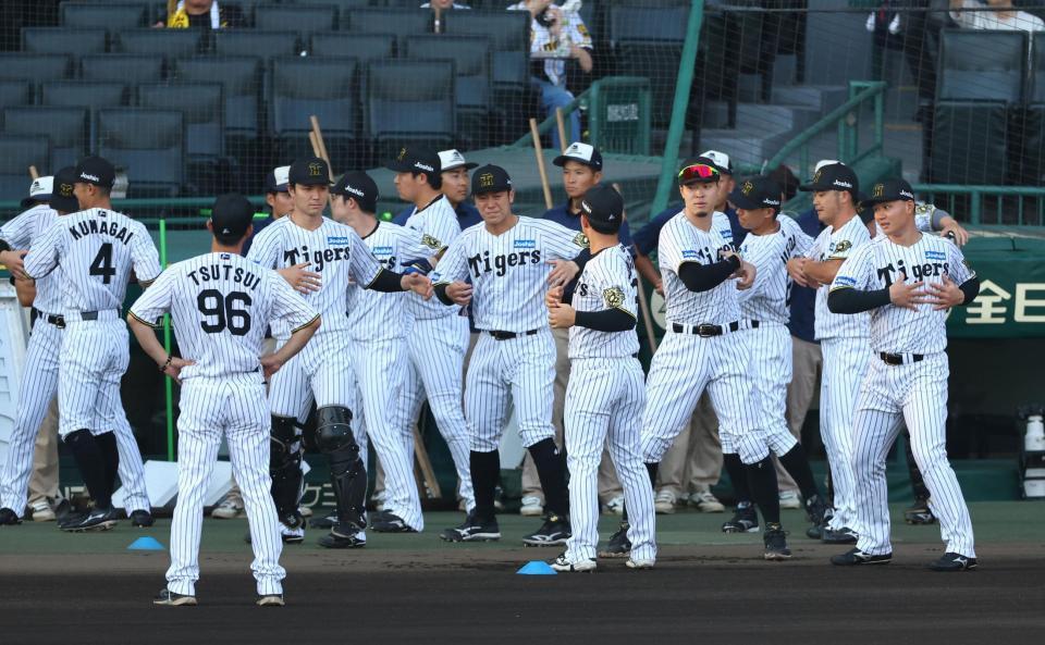 　試合前、ベンチ前でアップする阪神ナイン（撮影・山口登）