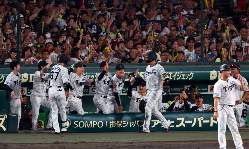 　２回、高寺の先制犠飛で生還した大山を迎える阪神ナイン（撮影・山口登）