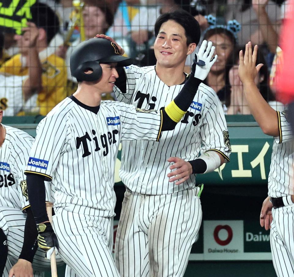 　６回、犠飛で追加点を挙げた近本（左）は木浪に迎えられる（撮影・田中太一）