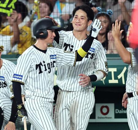 　６回、犠飛で追加点を挙げた近本（左）は木浪に迎えられる（撮影・田中太一）