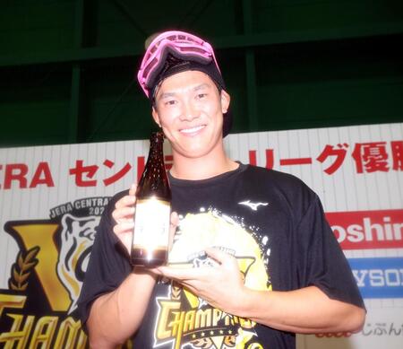 　ビールを手に写真に納まる湯浅