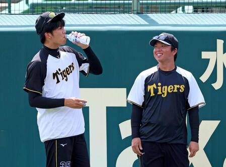 　練習前、才木（左）と談笑する村上（撮影・立川洋一郎）
