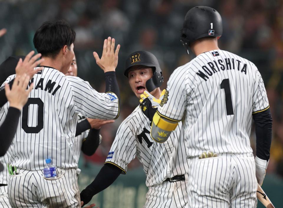 　６回、近本の犠飛で生還し、ナインとタッチを交わす坂本（中央）＝撮影・北村雅宏