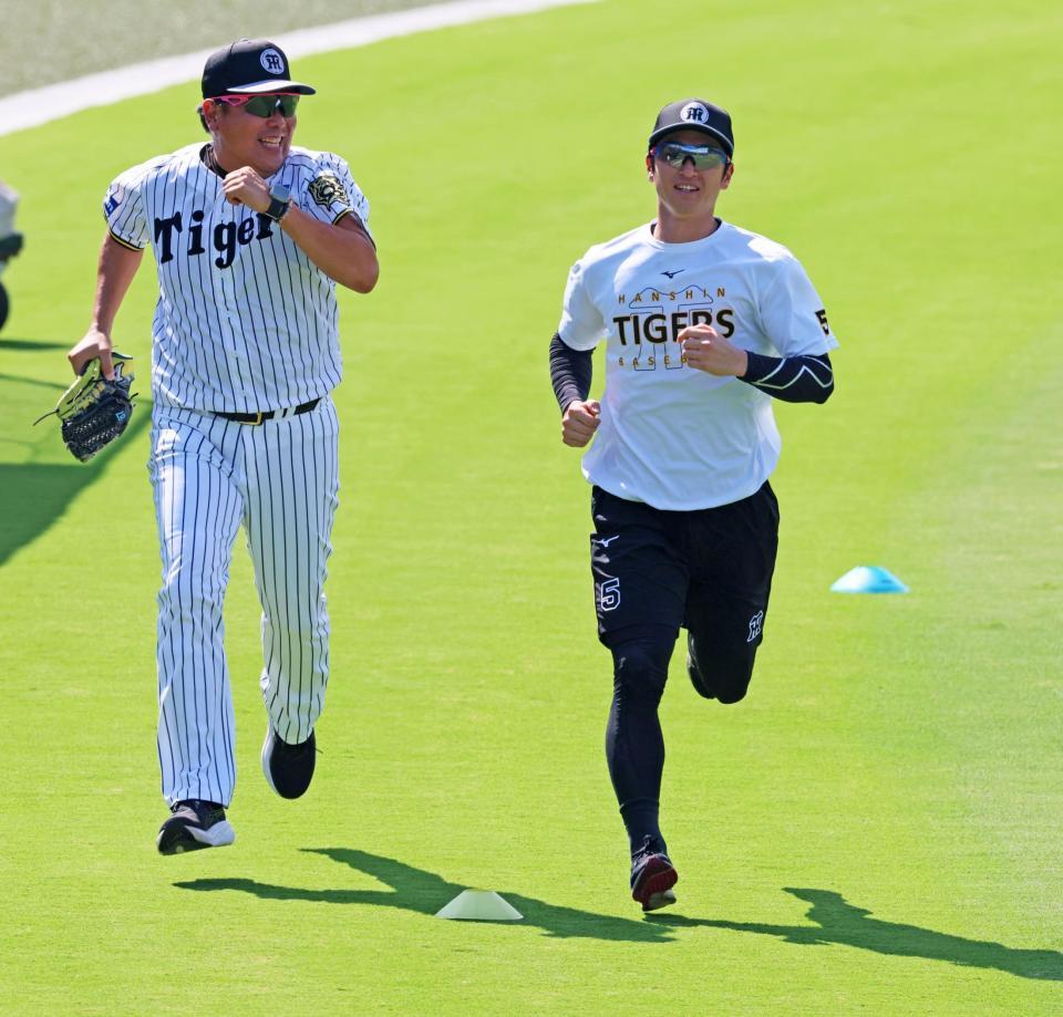 　野村バッテリーコーチ（左）とダッシュする近本（撮影・立川洋一郎）