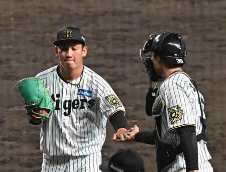 　９回を無失点に抑え、栄枝（右）とタッチを交わす伊原（撮影・西田忠信）