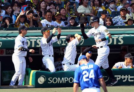 　１回、生還しナインに迎えられる佐藤輝（撮影・山口登）