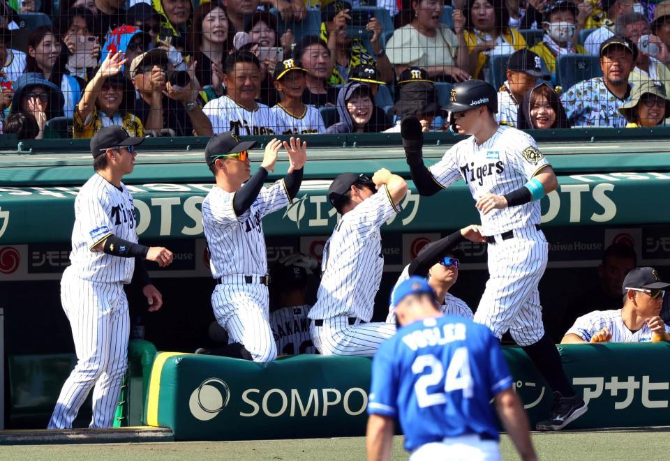 　１回、生還しナインに迎えられる佐藤輝（撮影・山口登）