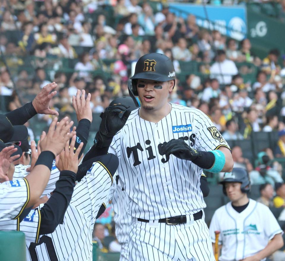 　５回、２ランを放ちナインとタッチを交わす佐藤輝（撮影・北村雅宏）