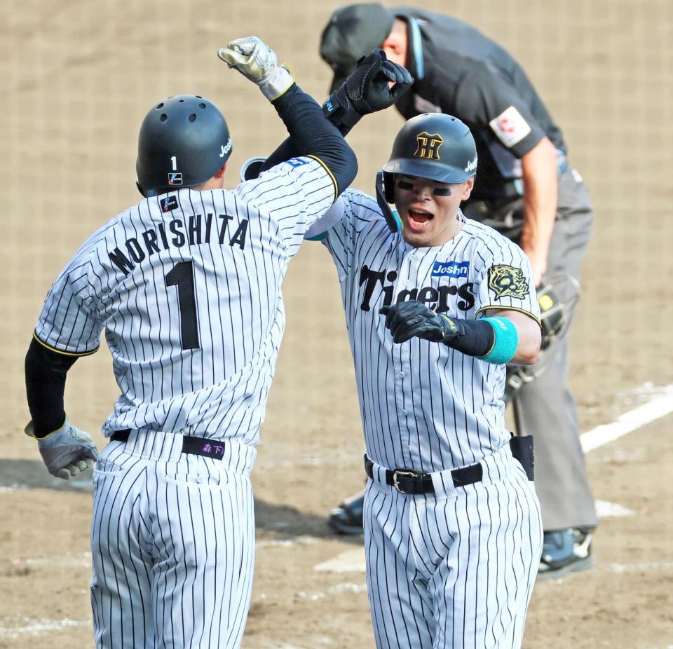 　５回、２打席連続の２ランを放ち森下（左）と歓喜のタッチを交わす佐藤輝（撮影・立川洋一郎）