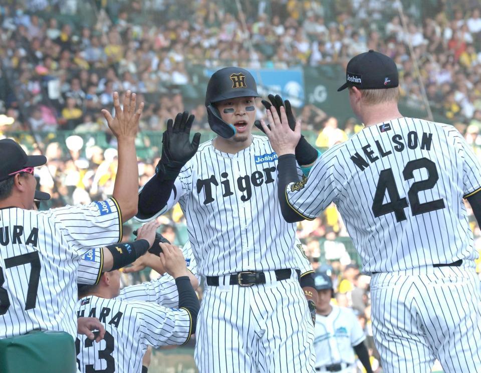 　３回、２ランを放ち、ネルソン（４２）とタッチを交わす佐藤輝（中央）＝撮影・北村雅宏