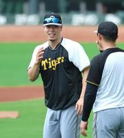 　練習中に森下と談笑する佐藤輝（左）＝撮影・北村雅宏