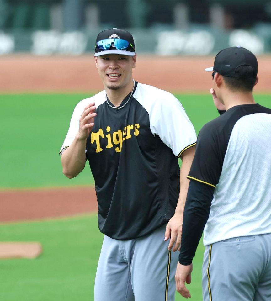 　練習中に森下と談笑する佐藤輝（左）＝撮影・北村雅宏