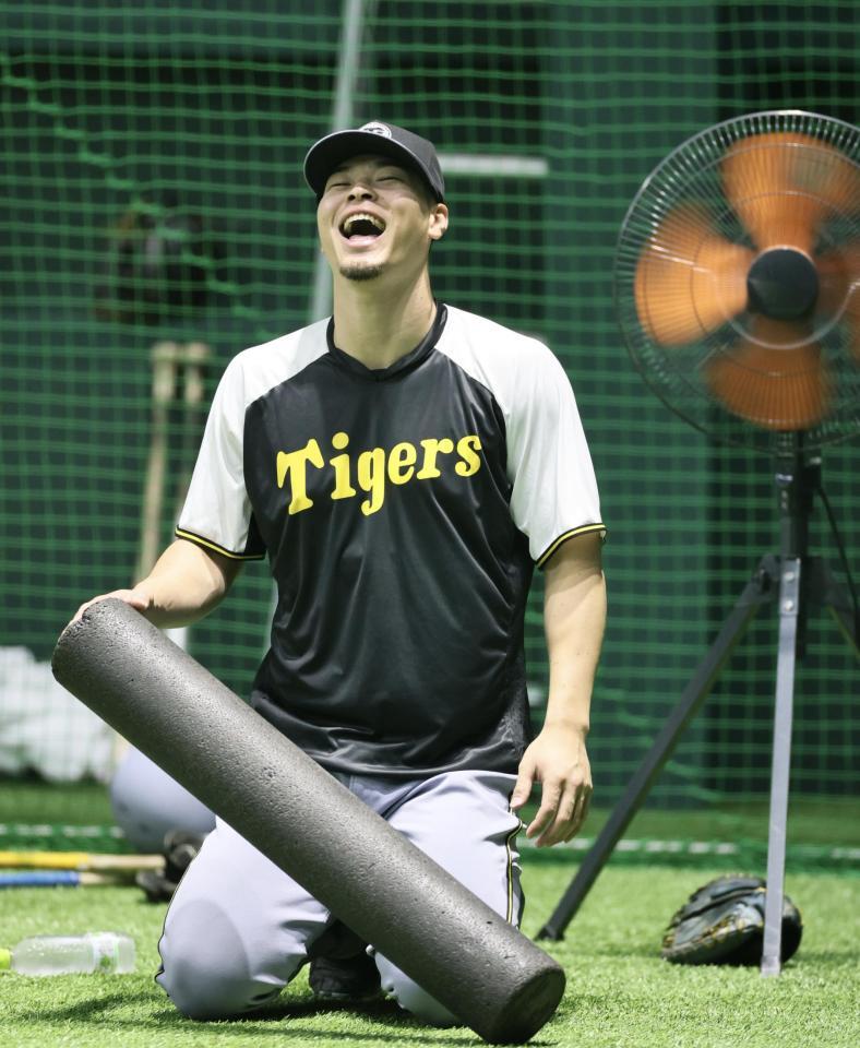 　ストレッチをしながら笑顔を見せる佐藤輝（撮影・田中太一）