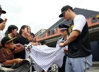 　引き揚げる際、ファンにサインをする佐藤輝（撮影・田中太一）