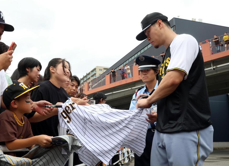 　引き揚げる際、ファンにサインをする佐藤輝（撮影・田中太一）