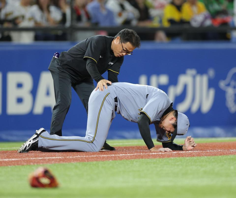 　６回、北村恵の打球が足に当たり、必死に痛みをこらえる才木（撮影・西岡正）