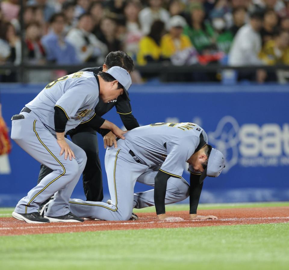 　６回、北村恵の打球が足に当たり、必死で痛みをこらえる才木（撮影・西岡正）