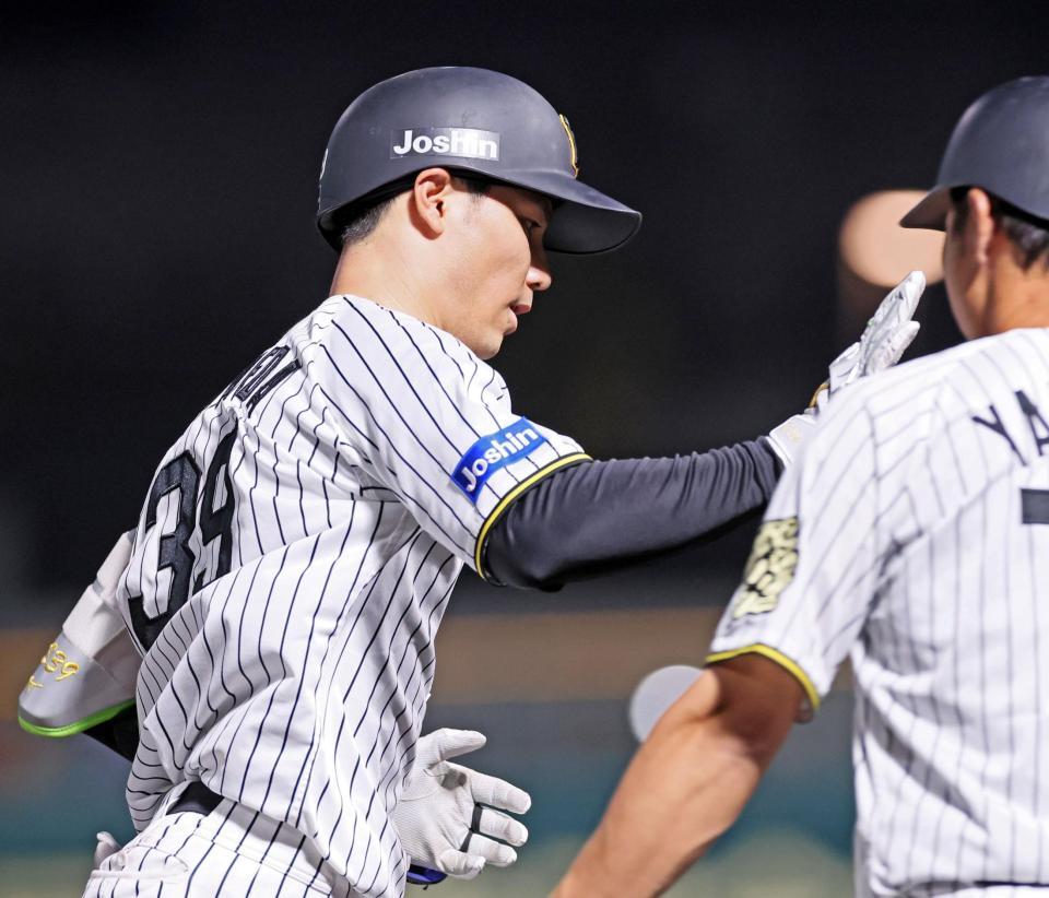 　２回、左翼スタンドへ先制ソロを放ちタッチを交わす栄枝（撮影・立川洋一郎）