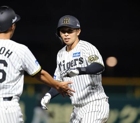 　７回、島田は中前に同点となる適時打を放ち、笑顔でタッチをかわす（撮影・坂部計介）