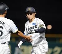 　７回、島田は中前に同点となる適時打を放ち、笑顔でタッチをかわす（撮影・坂部計介）