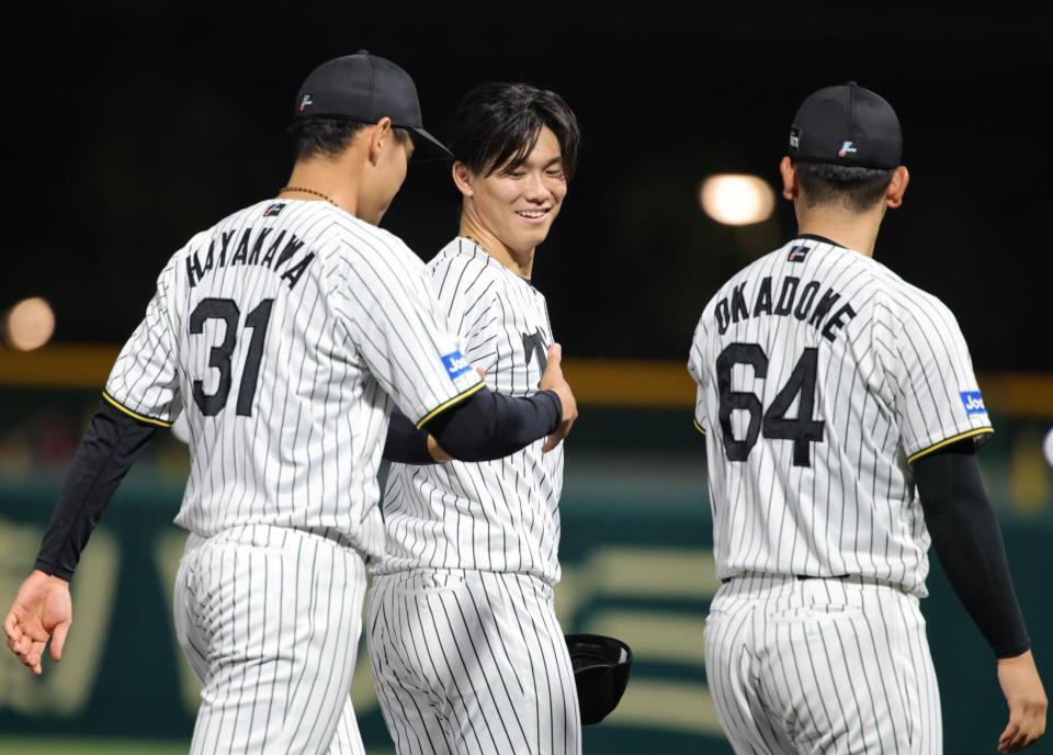 　試合後、笑顔で早川（３１）とタッチをかわす湯浅（撮影・坂部計介）