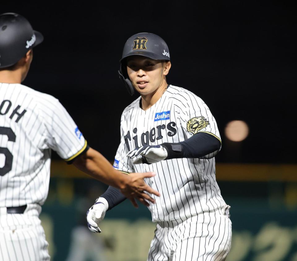 　７回、島田は中前に同点となる適時打を放ち、笑顔でタッチをかわす（撮影・坂部計介）