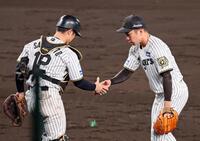 　９回を締めくくり坂本（左）と握手を交わす石井（撮影・立川洋一郎）