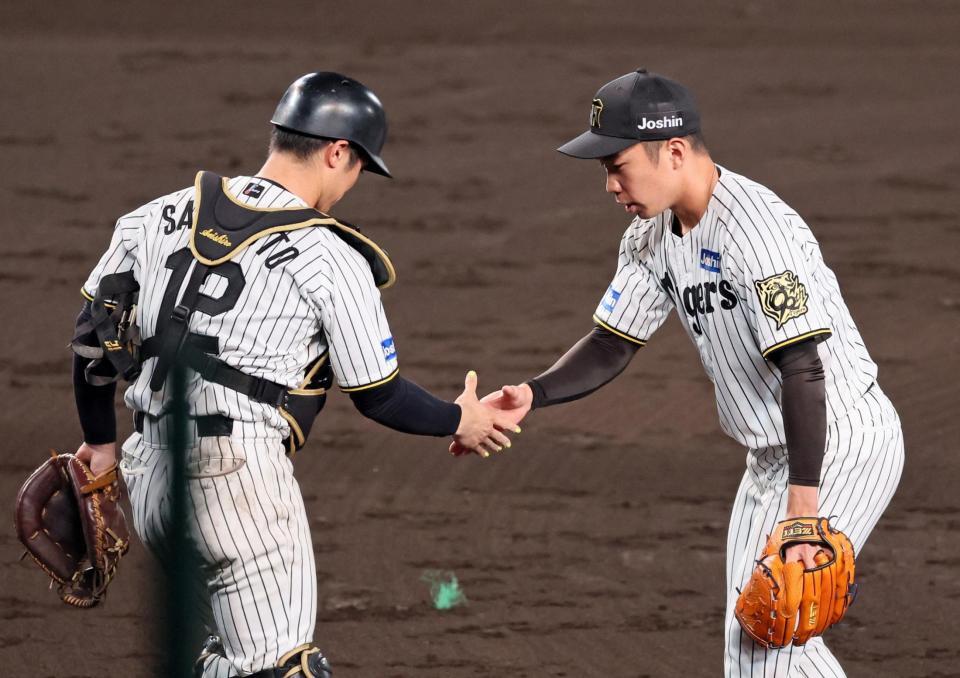 　９回を締めくくり坂本（左）と握手を交わす石井（撮影・立川洋一郎）