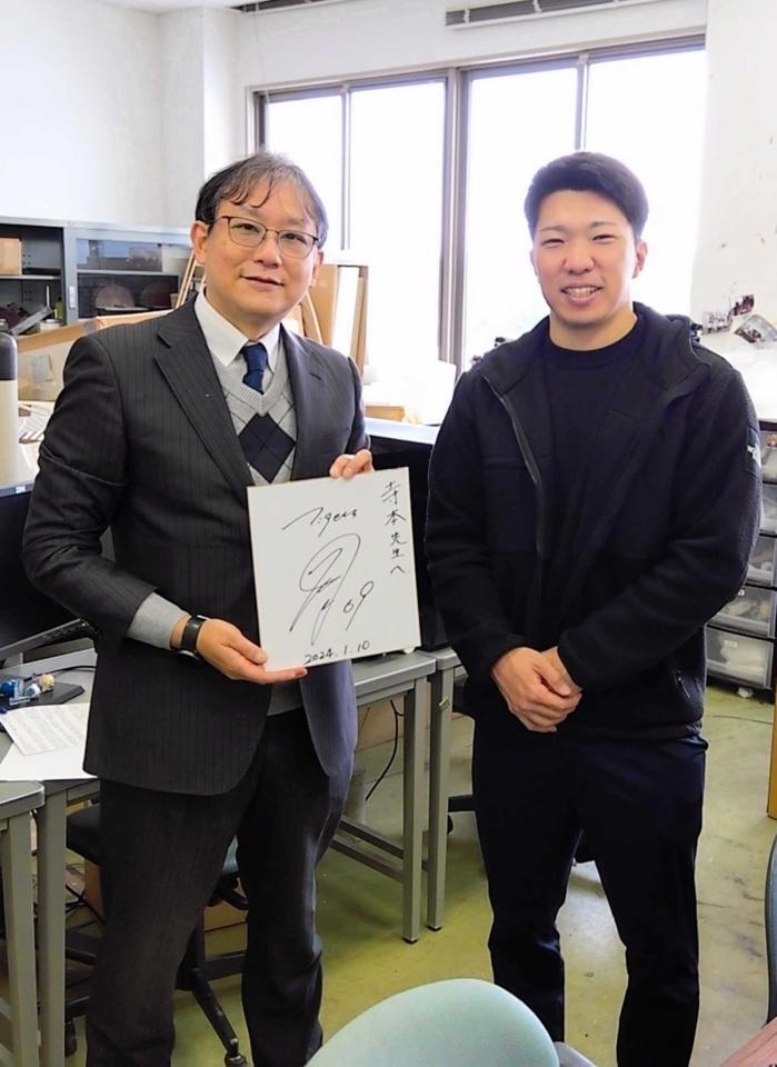　日本一に輝いた２３年のシーズンオフに母校を訪ねた石井（右）と寺本教授（提供写真）