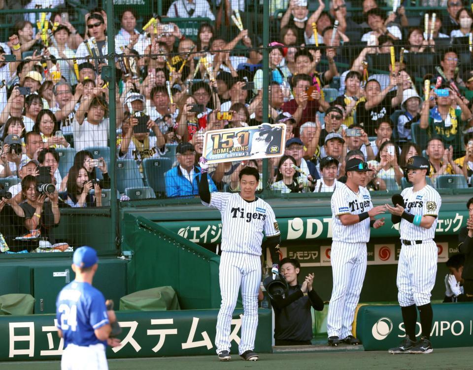 　７回、１５０号本塁打を記録する３ランを放ちボードを掲げる大山（撮影・立川洋一郎）