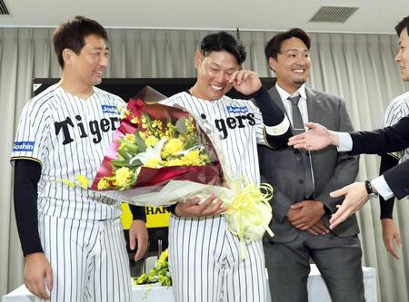 　岩崎（左）らチームメートから花束を受け取り、目頭を押さえる原口