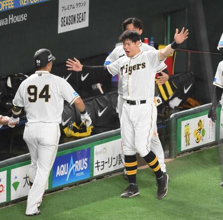 　巨人戦で２ランを放った代打原口（左）を迎える佐藤輝＝２３年８月１０日