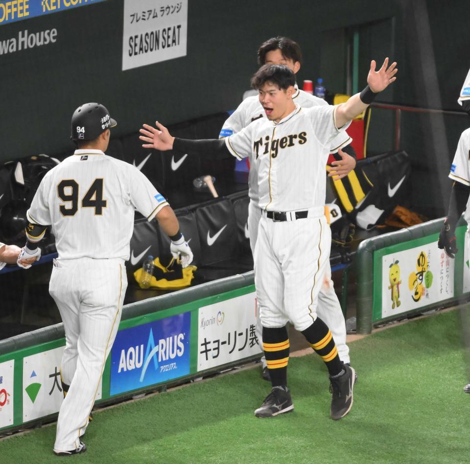 　巨人戦で２ランを放った代打原口（左）を迎える佐藤輝＝２３年８月１０日