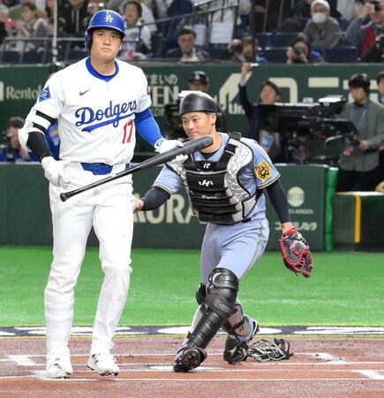 　今年３月のドジャース戦で、１回、空振り三振に倒れた大谷（左）にタッチする坂本