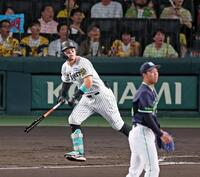 　１回、先制の左犠飛を放つ佐藤輝（撮影・立川洋一郎）