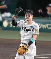 　２回表の守備に就き、スタンからの「テルコール」に応える佐藤輝（撮影・立川洋一郎）