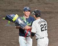 　藤川監督（右）から花束を受け取る高津監督（撮影・西田忠信）