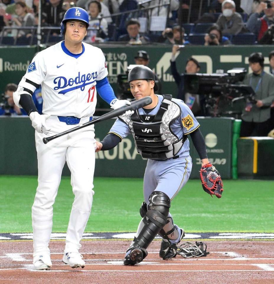 　今年３月のドジャース戦で、１回、空振り三振に倒れた大谷（左）にタッチする坂本