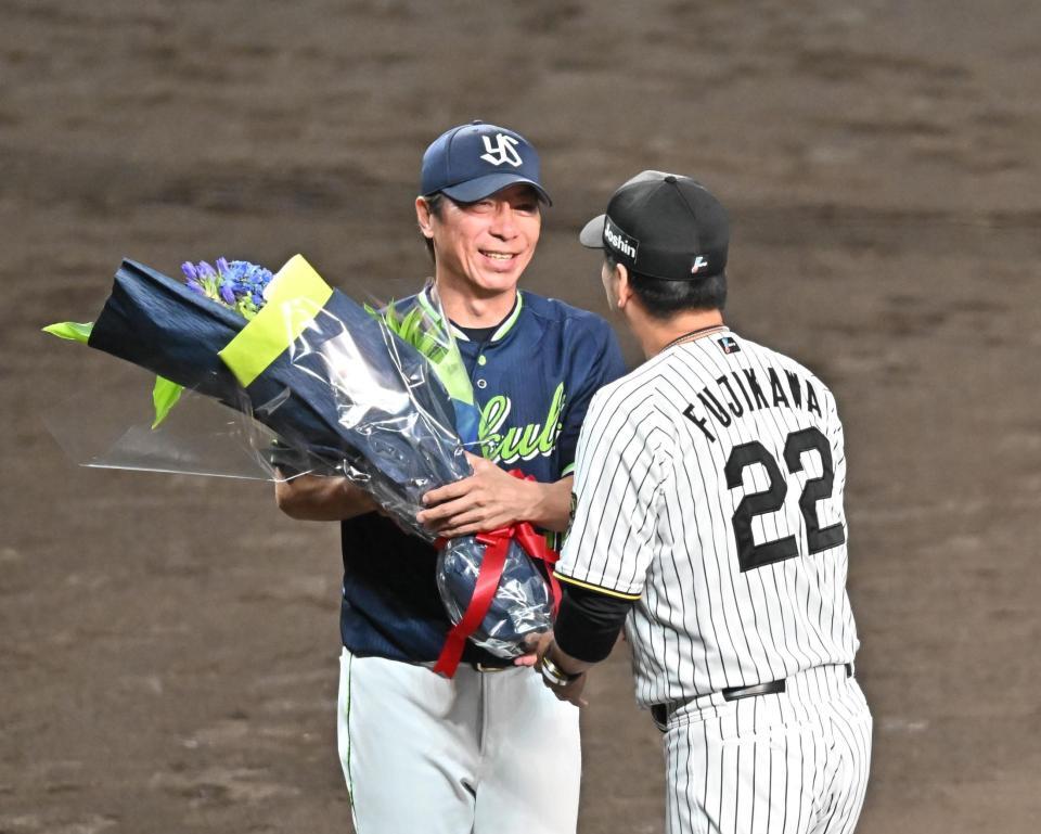 　藤川監督（右）から花束を受け取る高津監督（撮影・西田忠信）